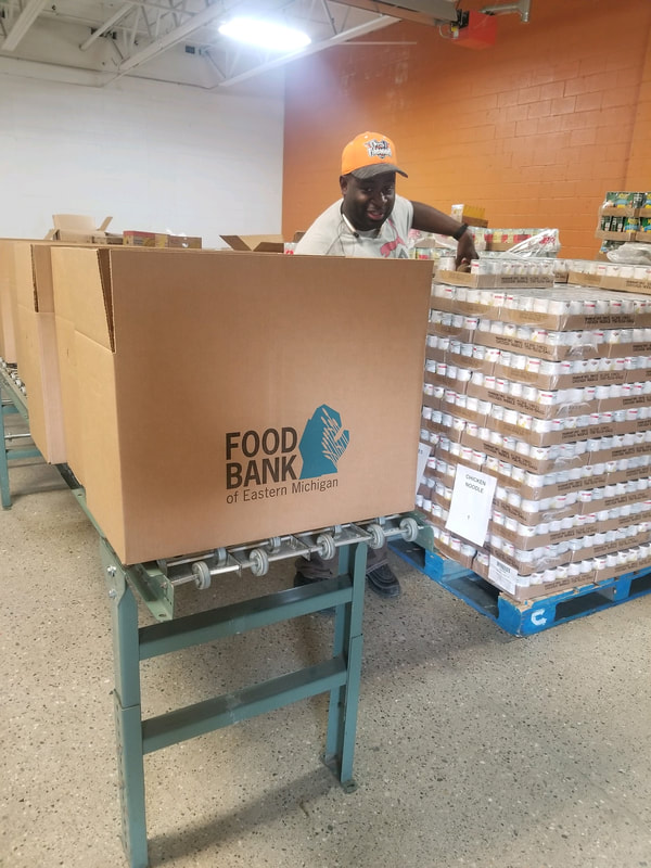 Volunteering to package food at the Food Bank of Eastern Michigan.